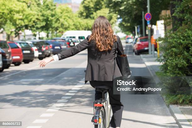 Joven Empresaria Mostrando A Su Vez En Bicicleta Foto de stock y más banco de imágenes de Andar en bicicleta - Andar en bicicleta, Dar vueltas, Bicicleta