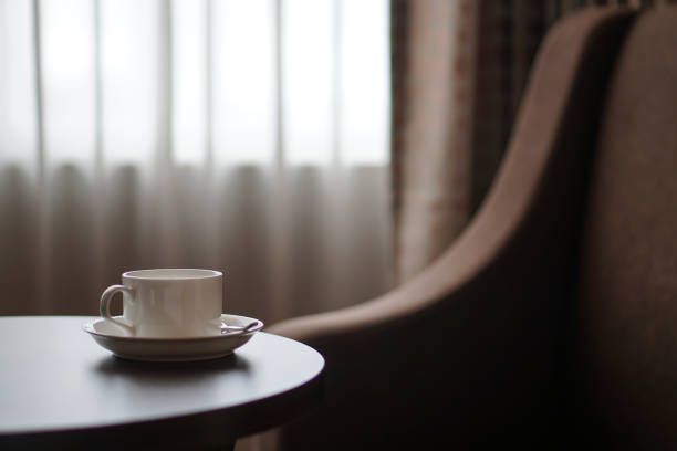 istock white coffee cup on the table by a sofa couch in hotel room 860609446