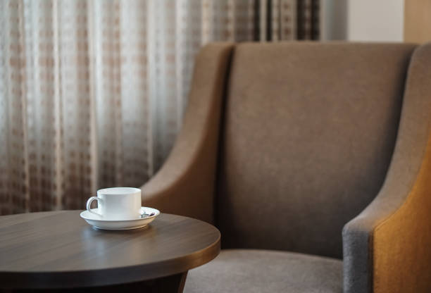 istock white coffee cup on the table by a sofa couch in hotel room 860609908