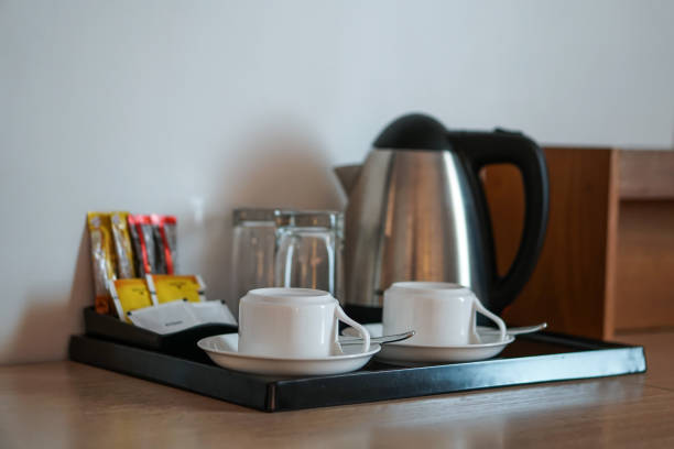 beverage set with coffee cup, kettle, glasses, tea, coffee, sugar in hotel room