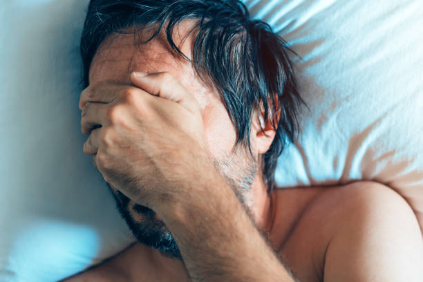 朝うつ病と男性の中年の危機 - hangover men crying bed ストックフォトと画像