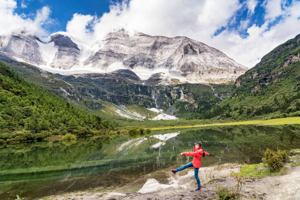 A young woman walking by the lake, Daocheng County, Sichuan province, China.