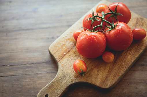 Tomatoes on a cutting board. Raw food.