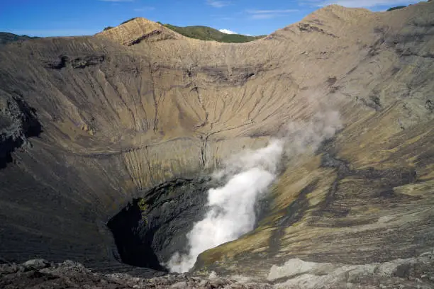 Crater inside of active volcano Mount Bromo with smoke coming out at the Tengger Semeru National Park in East Java, Indonesia.