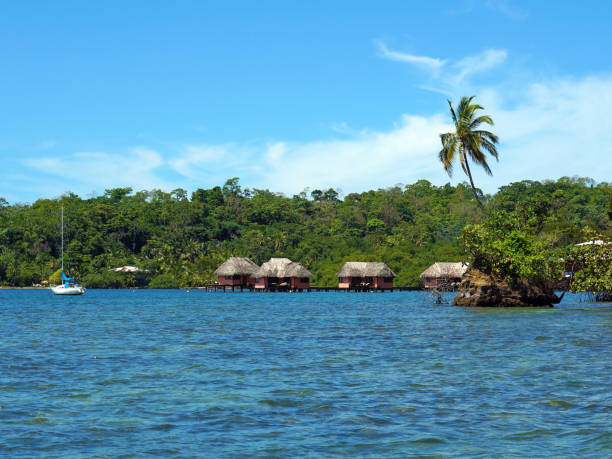 istock Islet and thatched cabins over the water 860621208