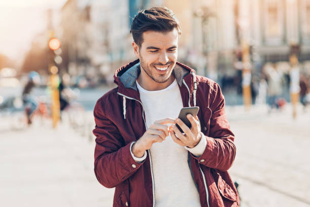 istock Smiling man texting on the street 860624330