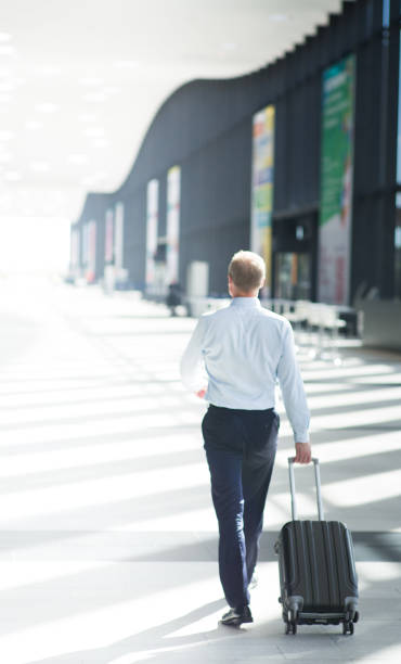 istock Business man walking with wheeled bag 860624446