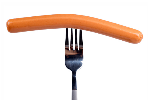 Tasty frankfurter sausage on a fork isolated on a white background