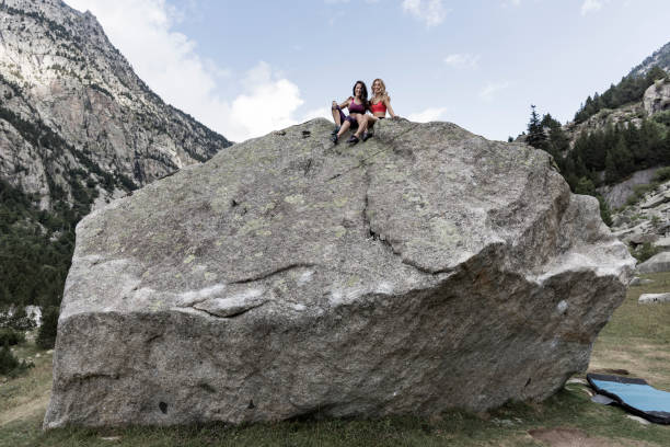 Two woman after rock climbing on top of boulder