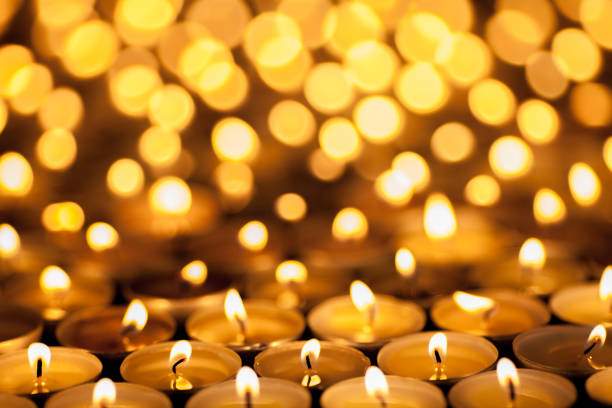 Diwali Festival of Lights. Beautiful candlelight. Selective focus on foreground of many burning tealight candles. Festival of Lights. Beautiful candlelight. Selective focus on foreground of many burning tealight candles. Diwali or Christmas celebration image. ian stock pictures, royalty-free photos & images