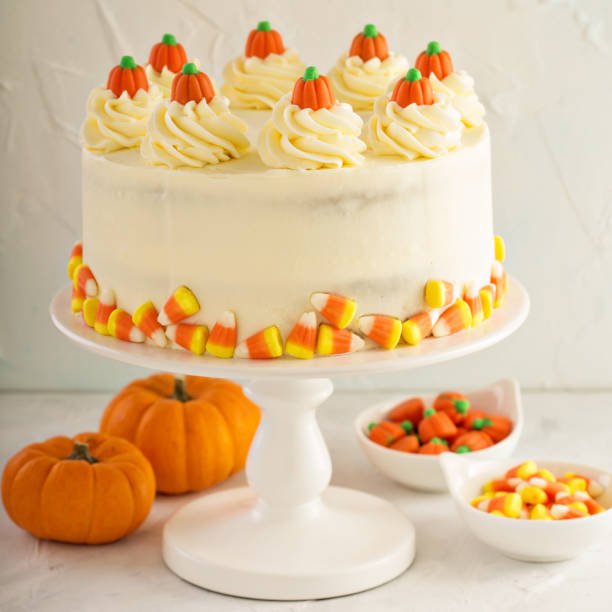 Pumpkin spice layered cake with cream cheese frosting decorated with candy, dessert for Halloween and Thanksgiving