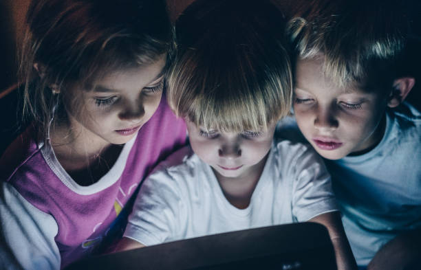 Three kids looking down at monitor