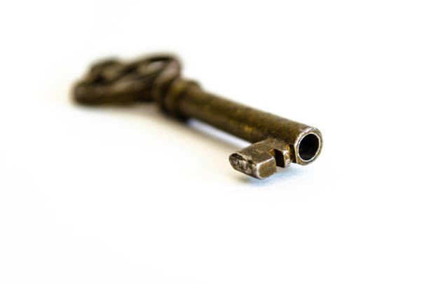 istock Antique Brass Skeleton Key end on White Background, shown at an angled  view macro closeup 860653970