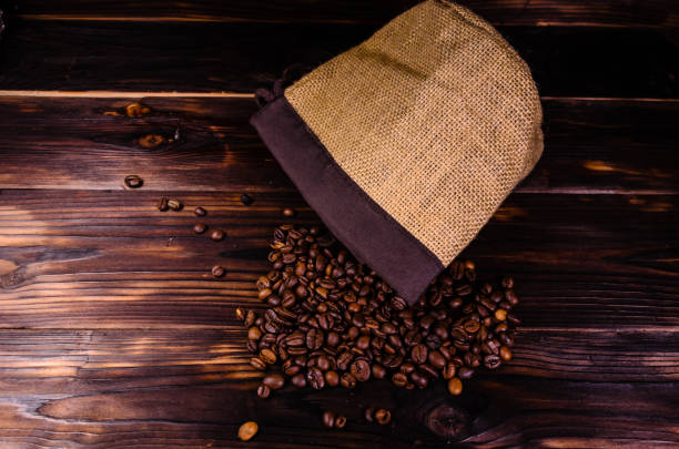 istock Roasted coffee beans in sack on wooden table 860657660