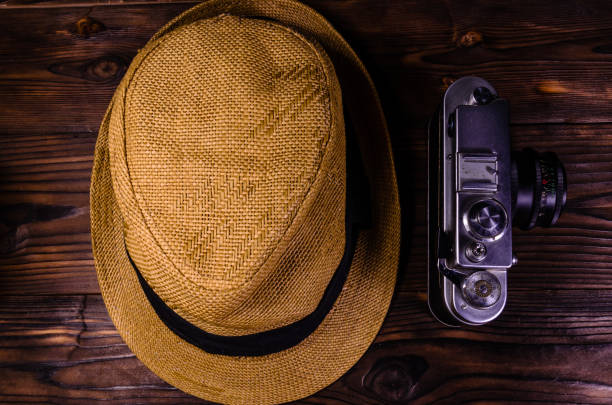 istock Old rangefinder camera and hat on a wooden table. Top view 860657666