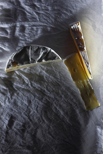 Camembert cheese cut on a white linen napkin in a retro style for the designer