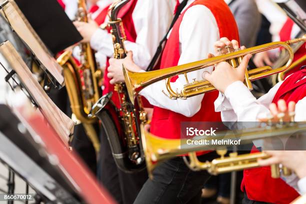 Musical Instrument Brass Band And Orchestra Concept Closeup Ensemble Of Musicians Playing On Trumpets And Saxophones In Red Concert Costumes Male Hands With Shiny Equipment Selective Focus Stock Photo - Download Image Now
