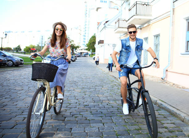 istock Happy funny young couple riding on bicycle 860677666