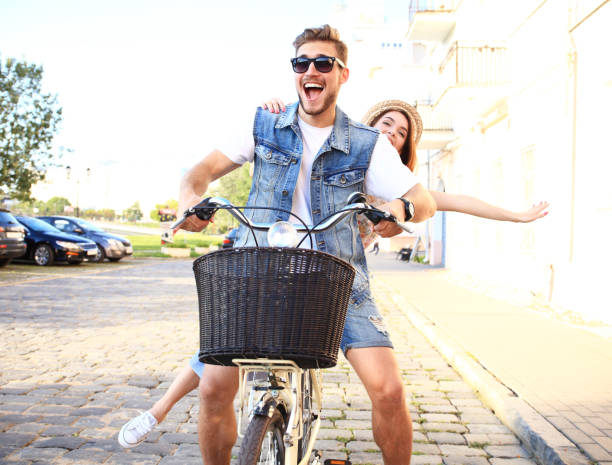 istock Happy funny young couple riding on bicycle 860677706