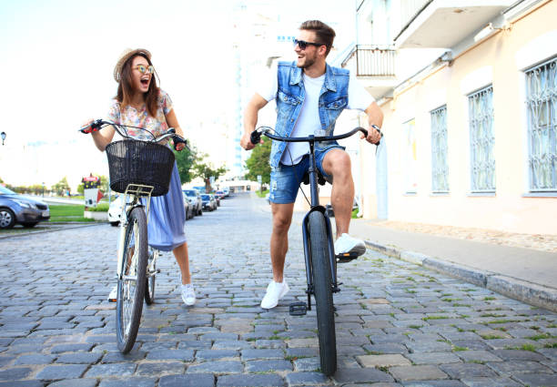 istock Happy funny young couple riding on bicycle 860677714