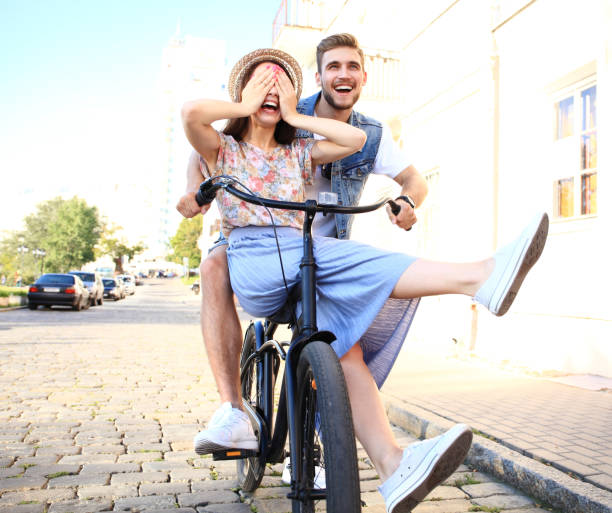 istock Happy funny young couple riding on bicycle 860677720