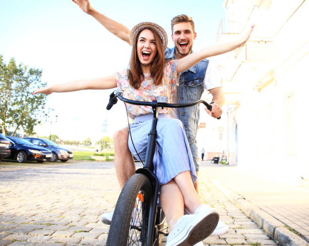 istock Happy funny young couple riding on bicycle 860677726