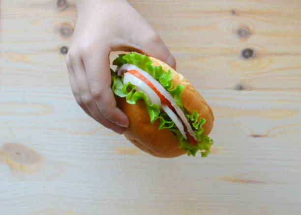 istock children's hand held a sandwich over the table 860693530