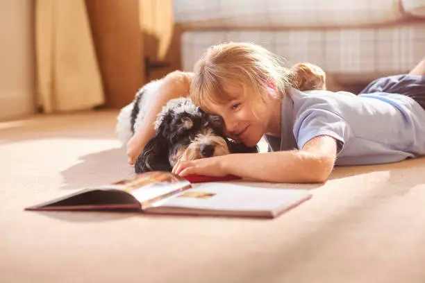Photo of cudding her dog reading a book
