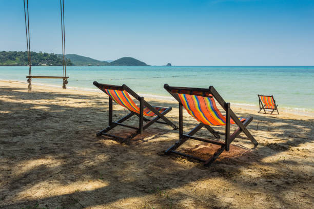istock sun beach chairs on shore near sea. 860700114