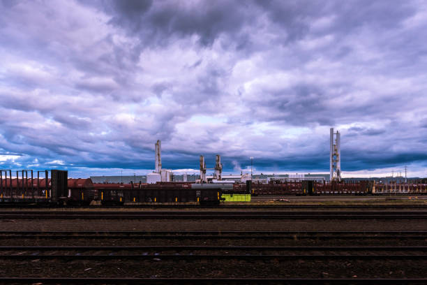 Edmonton, AB, Canada-July 2022; View over the Sherwood Park petroleum coke calcining plant and refinery and in front hundreds of rail or freight railroad cars with the city visible in haze in back