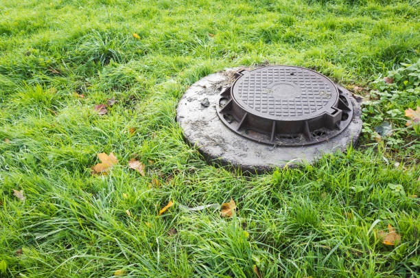 istock Round sewer manhole cover in green lawn 860707944