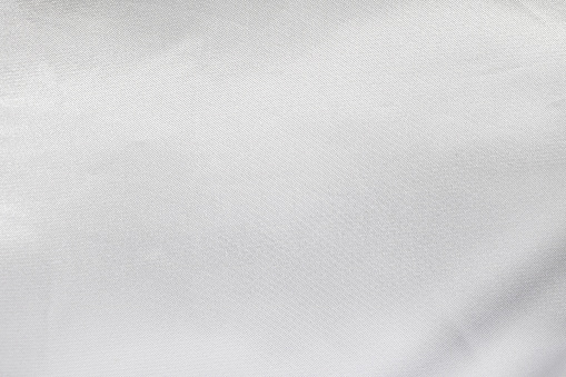White satin texture. Blank fabric background. Detail of silk material.