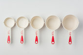 Set of Measuring Cups Lined on White Background Top View