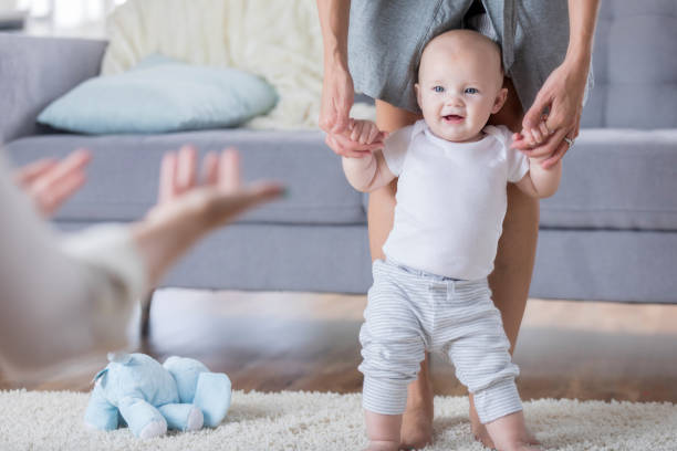 istock Baby being taught how to walk by parents 860715328