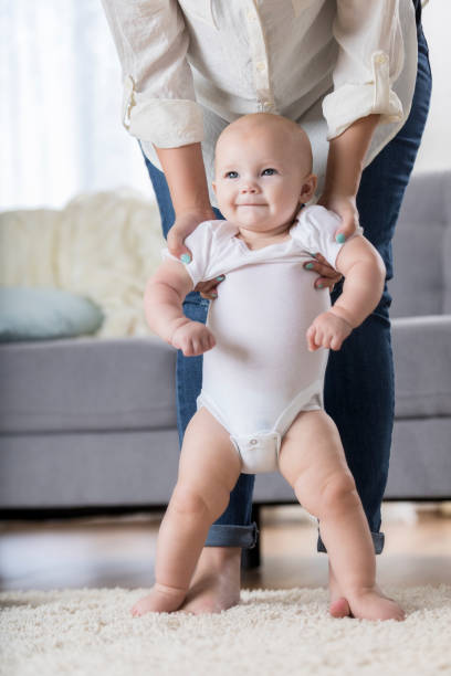 istock Adorable baby held in standing position from arms 860715332