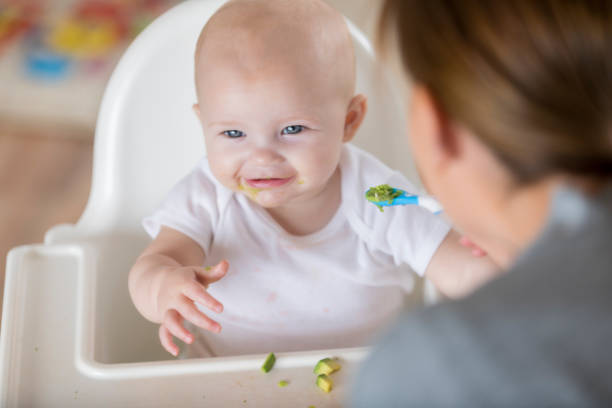 istock Adorable baby is distracted while being spoon fed 860715350