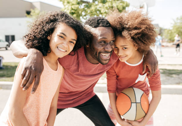 istock Dad and daughters  posing with basketball ball 860721382