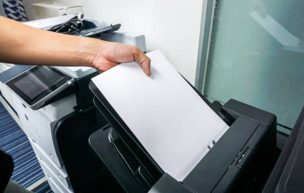 istock close up man put paper sheet into office printer tray 860739422