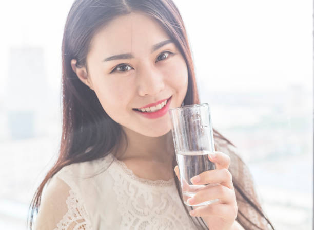 istock attractive woman standing on balcony drinking water after getting up 860739782