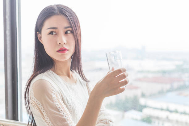 istock attractive woman standing on balcony drinking water after getting up 860739802