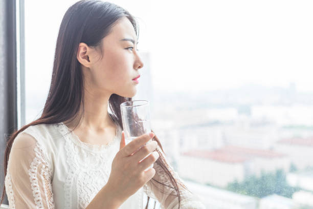 istock attractive woman standing on balcony drinking water after getting up 860739822