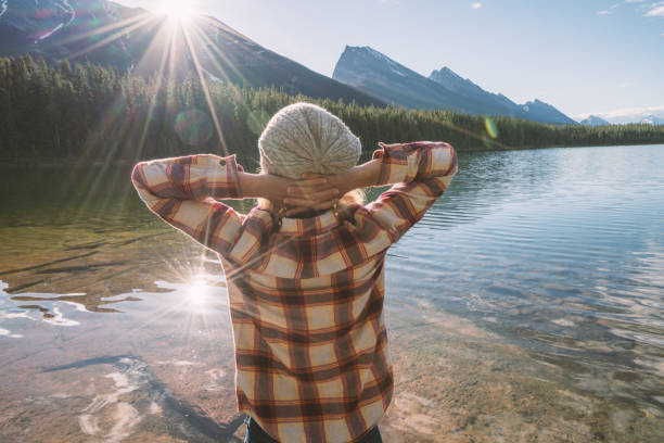 istock Young female watching sunrise from lake shore 860740306