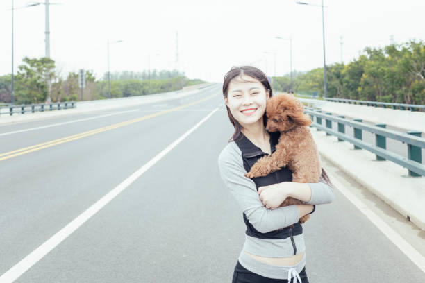 istock woman hugging her dog standing on road 860745894