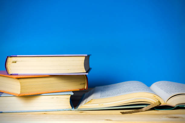 istock Closeup hardcover book isolated on blue background. Selective focus. 860746220