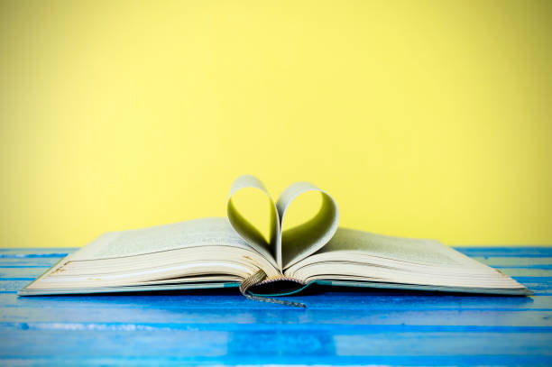 istock Closeup hardcover book isolated on yellow background. Selective focus. 860746232