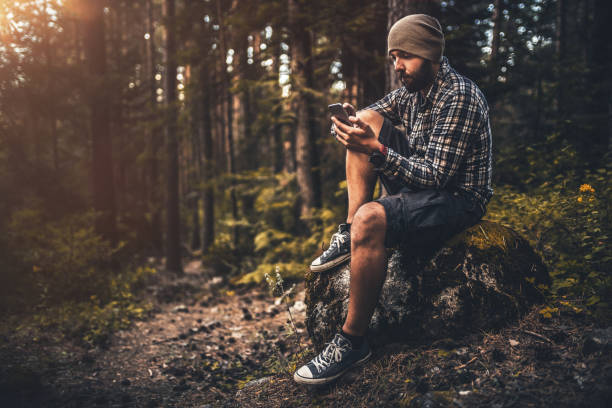 istock Traveler using smart phone sitting in the forest at sunset 860767666