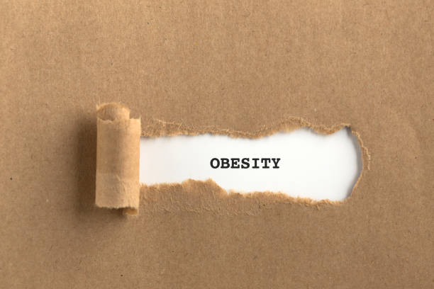 istock The text OBESITY behind torn brown paper 860771056