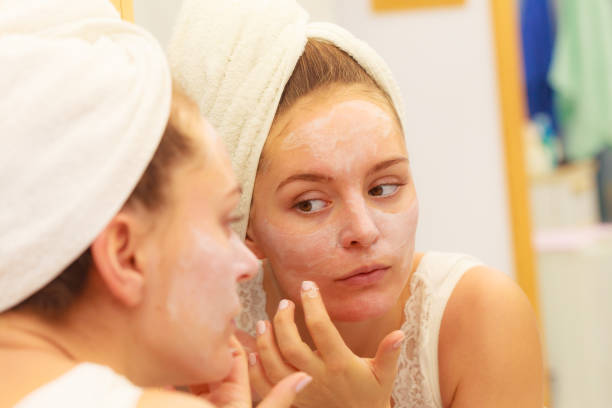 istock Woman applying mask cream on face in bathroom 860771484