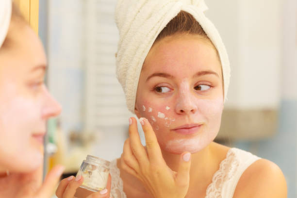 istock Woman applying mask cream on face in bathroom 860774668