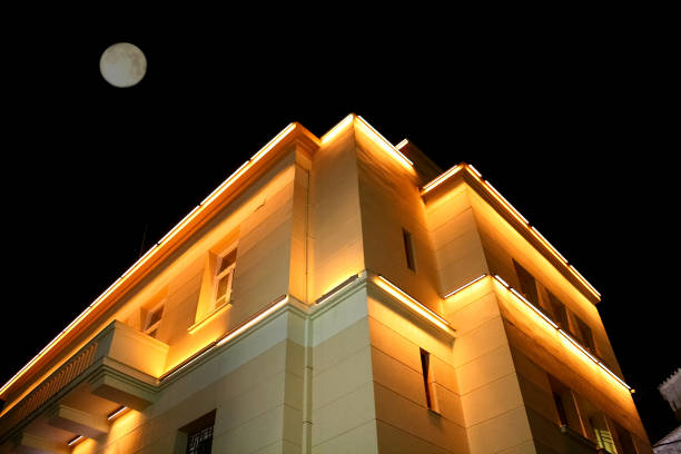 istock Lighted house with two floors and the moon above it 860782884